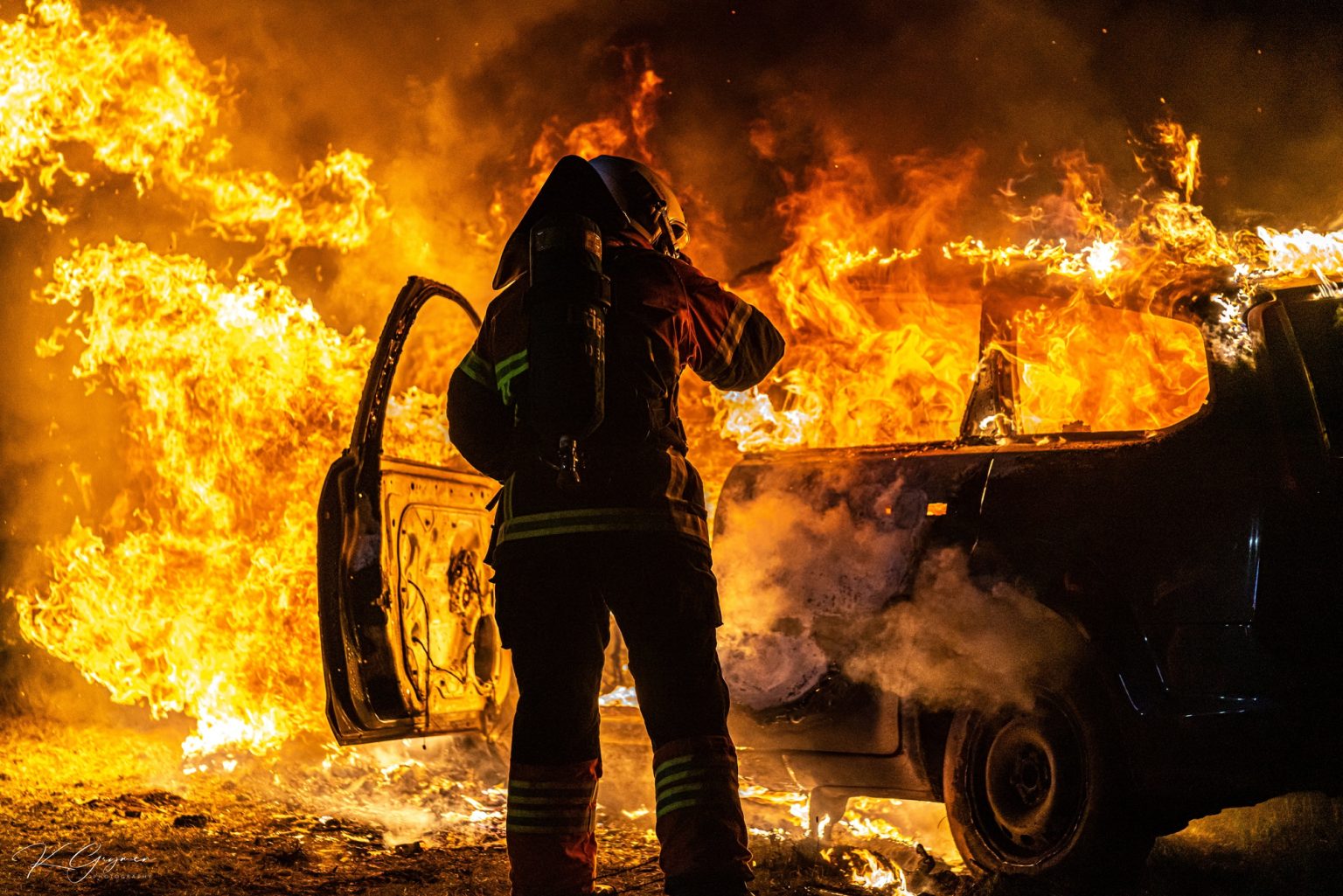 Beautiful shot of a fire man Extinguish the fire from a burning car
